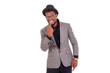 Yakışıklı bir iş adamının portresi şık bir takım elbise giymiş ve gülümserken beyaz dişlerini işaret ediyor..