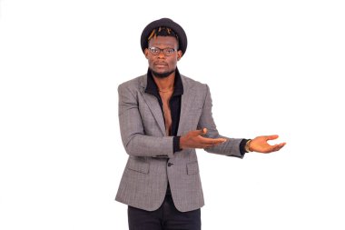 Yakışıklı, genç bir iş adamı şık bir takım elbise giyiyor ve iki elini de bir yana kaldırıyor..