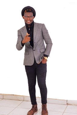 Yakışıklı genç bir iş adamı şık bir takım elbise giyiyor ve elini pantolonunun cebinde tutuyor..