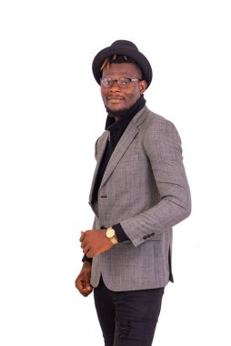 Yakışıklı genç işadamı zarif bir takım elbise giyiyor ve kafasında siyah bir şapka var..