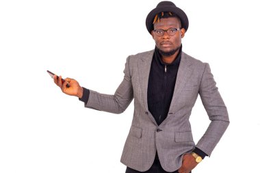 Zarif takım elbiseli ve elinde cep telefonu olan yakışıklı bir iş adamı..