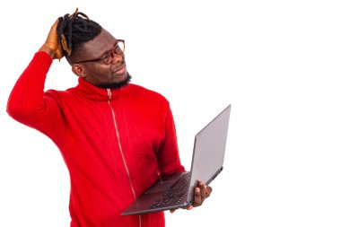 Kırmızı kazak giyen yakışıklı genç adamın dizüstü bilgisayarı var..