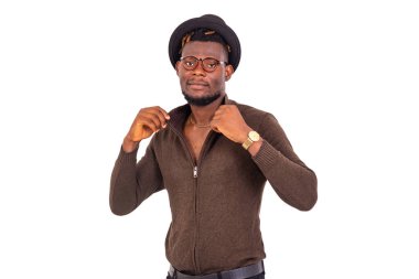 Beyaz arka planda duran yakışıklı genç bir adam yakasını tutuyor ve kameraya bakıyor..