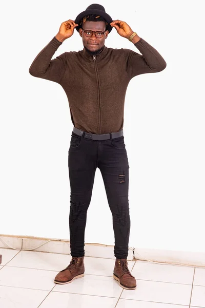 Ένας Όμορφος Νεαρός Άνδρας Γυαλιά Στέκεται Πάνω Λευκό Φόντο Προσαρμόζοντας — Φωτογραφία Αρχείου