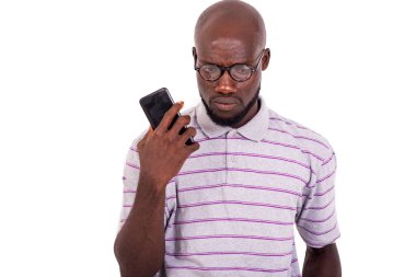 Optik gözlüklü genç adam cep telefonundan sesli mesaj dinliyor..