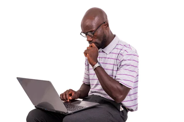 眼鏡をかけた青年がノートパソコンを操作している椅子に座って — ストック写真