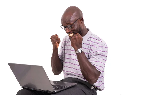 年轻男子戴着眼镜 坐在椅子上 拿着笔记本电脑 举手表决获胜 — 图库照片