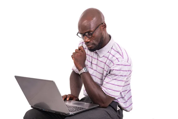 椅子に座ってノートパソコンを操作する眼鏡をかけた青年 — ストック写真