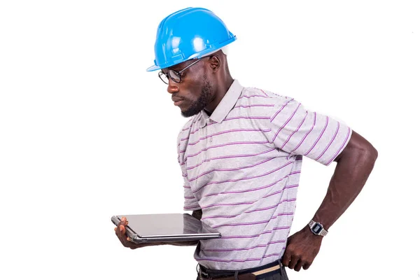 青いセーフティヘルメットをかぶってノートパソコンを持っている若い男のエンジニア — ストック写真