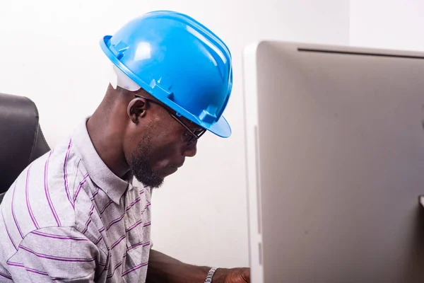 Jonge Man Ingenieur Met Blauwe Veiligheidshelm Zittend Aan Het Bureau — Stockfoto