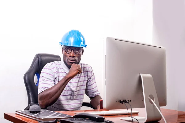 Молодой Человек Инженер Синем Защитном Шлеме Сидит Рабочем Месте Офисе — стоковое фото