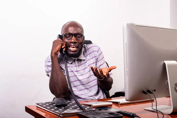Młody Biznesmen Siedzi Przy Biurku Twarzą Laptopa Rozmawia Przez Telefon — Zdjęcie stockowe