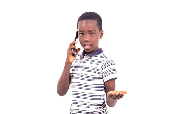 Tシャツを着た若い男の子が携帯電話で話している白い背景に立っています — ストック写真