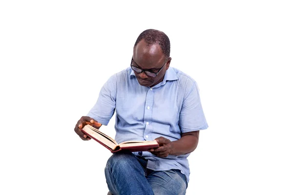 Hombre Maduro Gafas Sentado Taburete Sobre Fondo Blanco Leyendo Libro —  Fotos de Stock