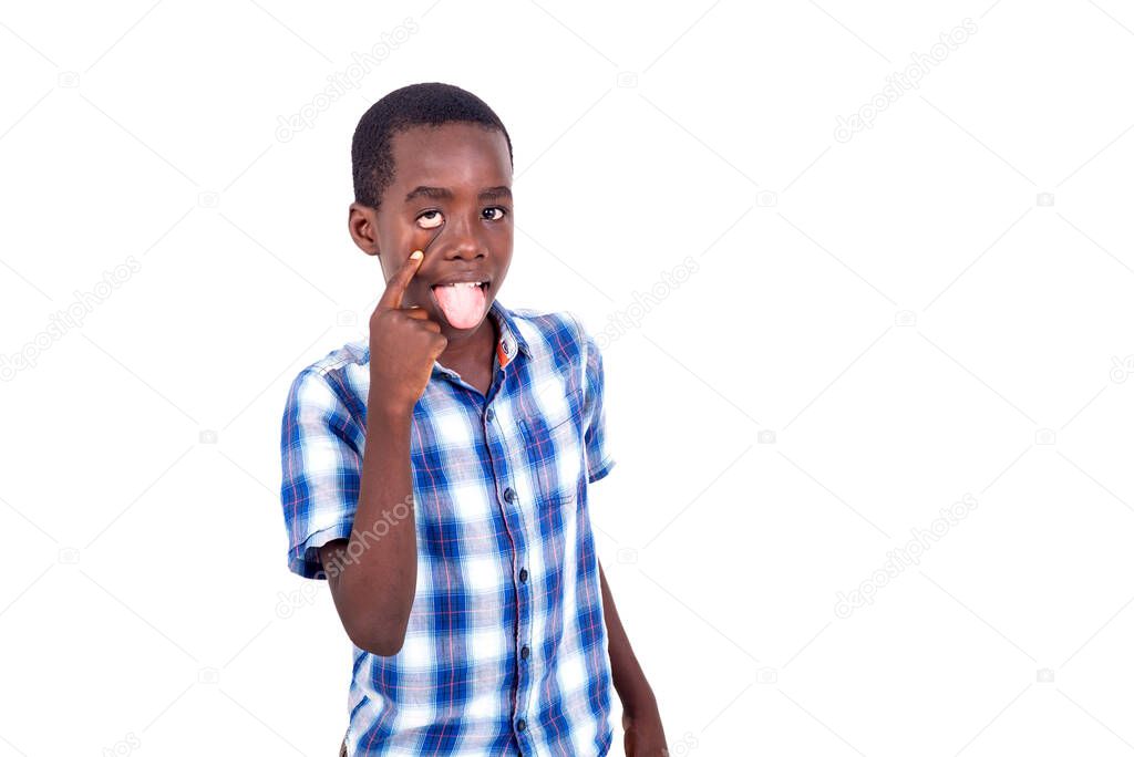 young boy in checkered shirt standing on white background making faces showing his tongue and eye.