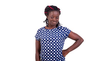 Genç, gülümseyen bir kadın kalçasını tutuyor ve beyaz arka planda tek başına duruyor..