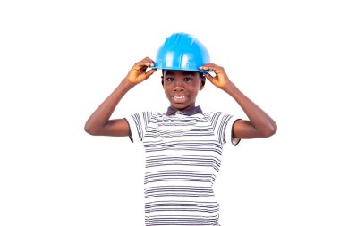 Beyaz arka planda duran tişörtlü genç adam inşaat kaskı takıyor ve gülümseyen kameraya bakıyor..