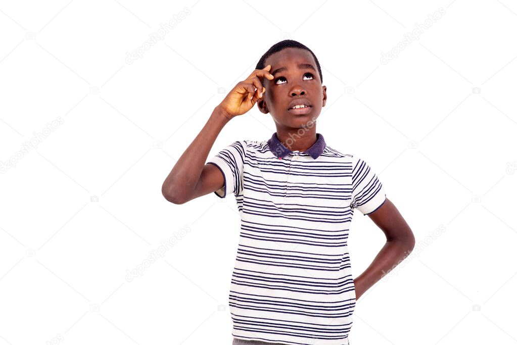Teenager standing thinking focused on doubt with finger on forehead and looking up wondering