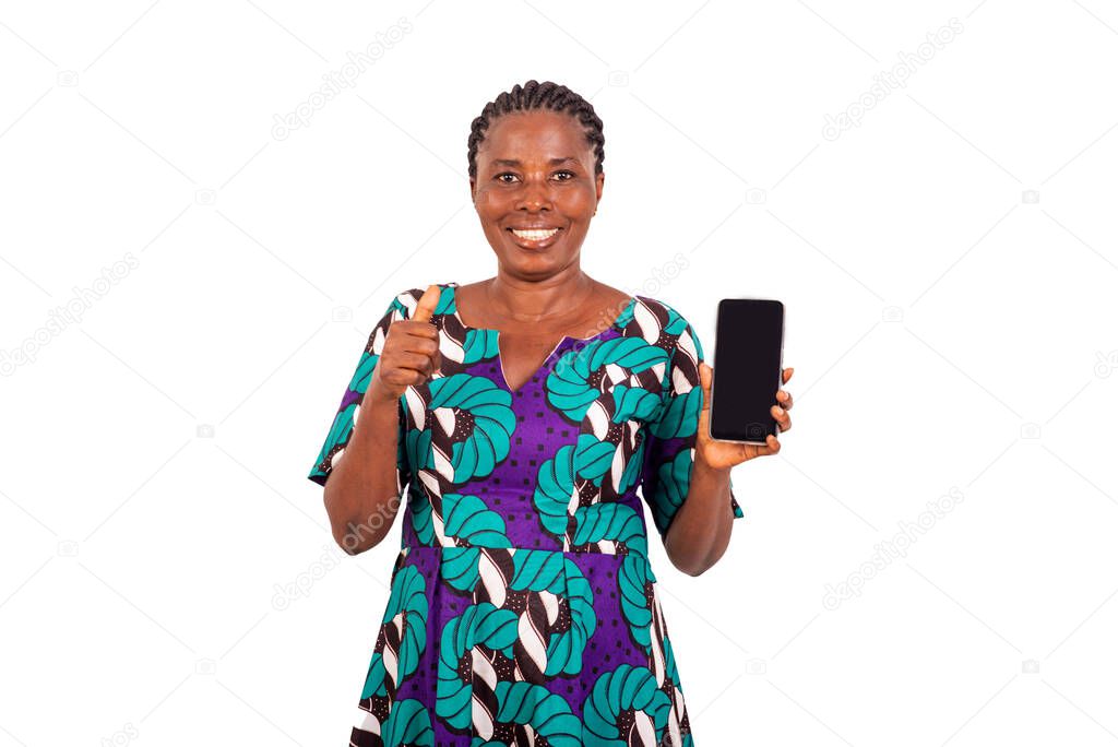 beautiful woman in loincloth dress standing on white background presenting cellphone while showing okay gesture while laughing.