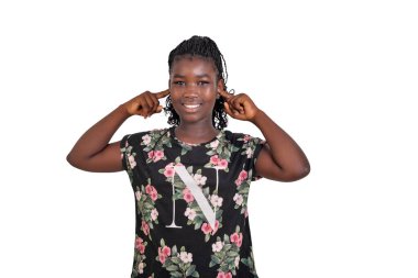 Çiçekli gecelikli genç kız beyaz arka planda duruyor parmaklarıyla kulaklarını örtüyor..