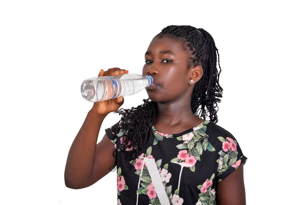 美しい肖像画若いアフリカの女の子は白い背景にミネラルウォーターのボトルを飲んで — ストック写真