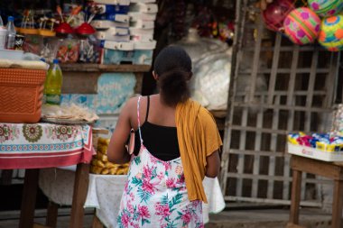 Abidjan, fildişi sahili - 16 Mart 2022: Arkadan alışveriş yapmak için bir dükkana giden genç kadının portresi