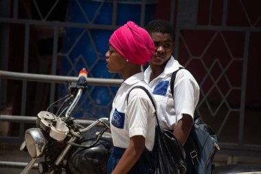 Abidjan, Ivory Coast- March 18, 2022: young students in uniform going to school while carrying backpacks.