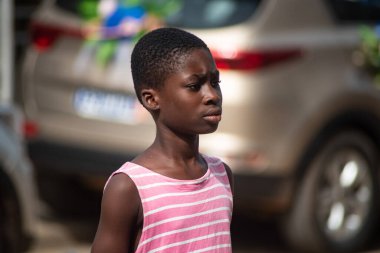 Abidjan, Fildişi Sahili - 26 Mart 2022: Kırmızı çizgili tişörtlü genç kızın portresi, profil manzaralı