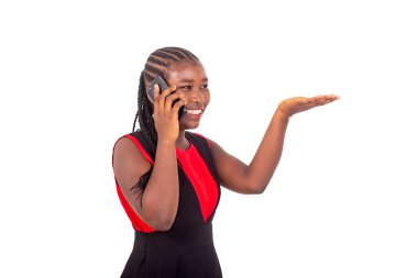 Kırmızı ve siyah elbiseli güzel bir kız beyaz arka planda duruyor cep telefonuyla konuşuyor ve elini kaldırıyor, gülüyor..