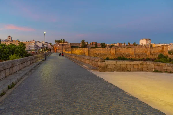 Sunset view of roman bridge over river Guadiana leading to Alcazaba fortress in Merida, Spain