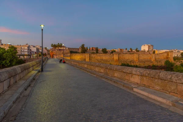 Sunset view of roman bridge over river Guadiana leading to Alcazaba fortress in Merida, Spain