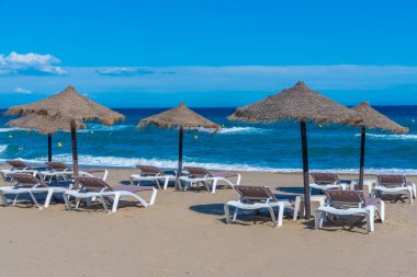 Marbella, İspanya 'daki Playa de Venüs' te güneşlik ve şemsiyeler.