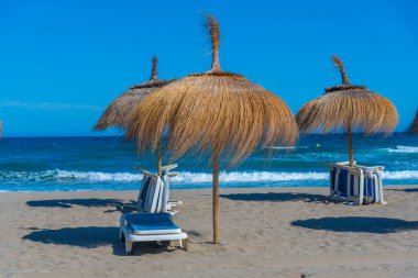 Marbella, İspanya 'daki Playa de Venüs' te güneşlik ve şemsiyeler.