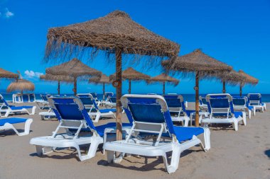 Marbella, İspanya 'daki Playa de Venüs' te güneşlik ve şemsiyeler.