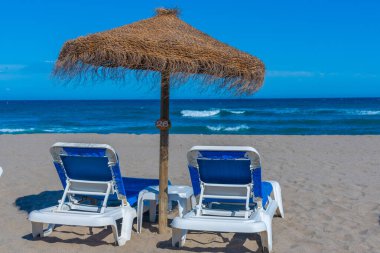 Marbella, İspanya 'daki Playa de Venüs' te güneşlik ve şemsiyeler.