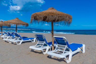 Marbella, İspanya 'daki Playa de Venüs' te güneşlik ve şemsiyeler.