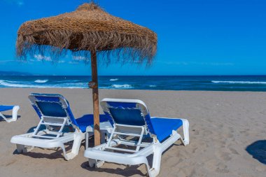 Marbella, İspanya 'daki Playa de Venüs' te güneşlik ve şemsiyeler.