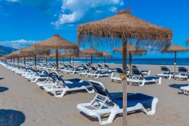 Marbella, İspanya 'daki Playa de Venüs' te güneşlik ve şemsiyeler.