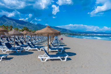 Marbella, İspanya 'daki Playa de Venüs' te güneşlik ve şemsiyeler.
