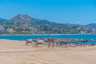 İnsanlar Malaga, İspanya 'daki Malagueta plajında güneşli bir günün tadını çıkarıyorlar.