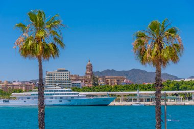 Malaga, İspanya 'da arka planda katedrali olan büyük bir yat.