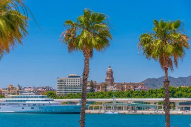 Malaga, İspanya 'da arka planda katedrali olan büyük bir yat.