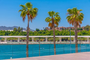 İspanya, Malaga 'daki Paseo del Muelle gezinti alanının arkasındaki Alcazaba kalesi.