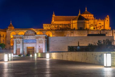 İspanya 'nın Cordoba şehrinde, ufukta La mezquita katedrali olan eski Roma köprüsünün günbatımı manzarası.