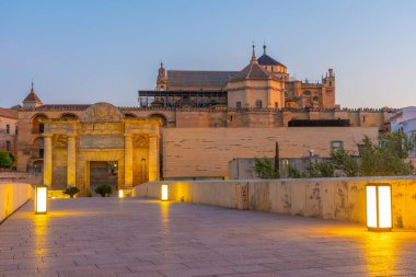 İspanya 'nın Cordoba şehrinde, ufukta La mezquita katedrali olan eski Roma köprüsünün gündoğumu manzarası.