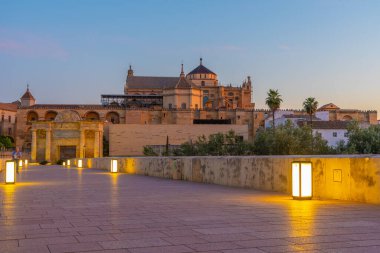 İspanya 'nın Cordoba şehrinde, ufukta La mezquita katedrali olan eski Roma köprüsünün gündoğumu manzarası.