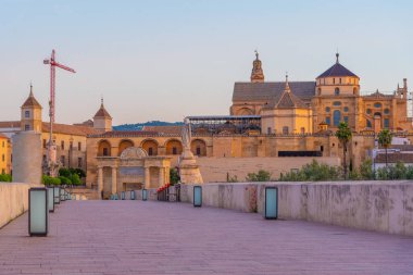 İspanya 'nın Cordoba şehrinde, ufukta La mezquita katedrali olan eski Roma köprüsünün gündoğumu manzarası.