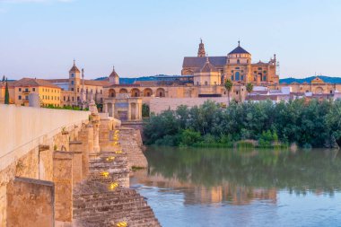 İspanya 'nın Cordoba şehrinde, ufukta La mezquita katedrali olan eski Roma köprüsünün gündoğumu manzarası.
