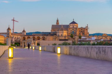 İspanya 'nın Cordoba şehrinde, ufukta La mezquita katedrali olan eski Roma köprüsünün gündoğumu manzarası.