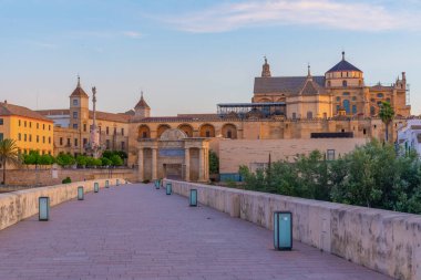 İspanya 'nın Cordoba şehrinde, ufukta La mezquita katedrali olan eski Roma köprüsünün gündoğumu manzarası.